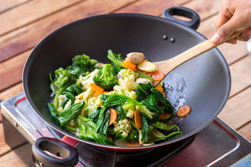 people cooking and stirring chinese food capcay