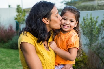Lovely mother kissing her daughters cheek