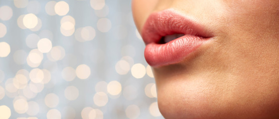 close up of young woman lips over holidays lights