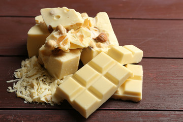 White chocolate pieces with nuts on color wooden background