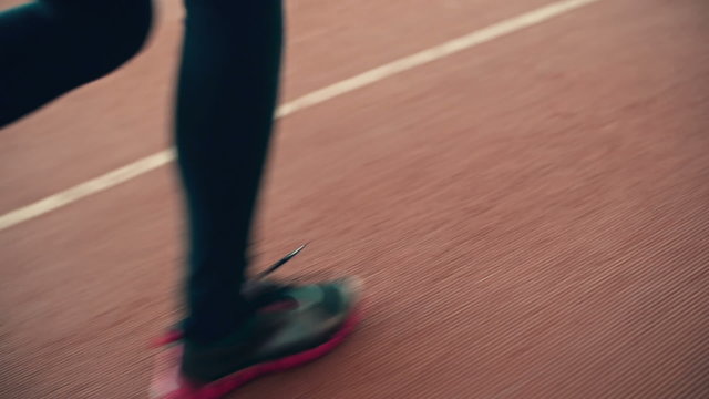 Close-up of female legs running on running track