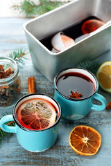 Tasty mulled wine and spices, on blue wooden background, close-up