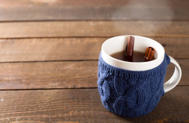 Mulled wine in a cute cup over wooden background