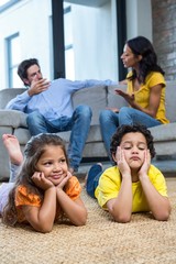 Children laying on the carpet in living room