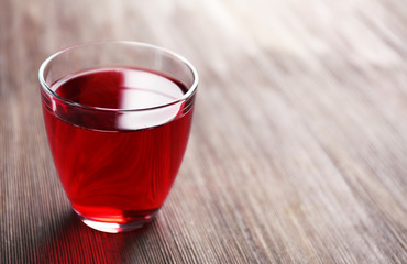 A glass of tasty garnet juice, on wooden background