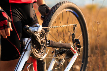 Young man repairing mountain bike in the forest