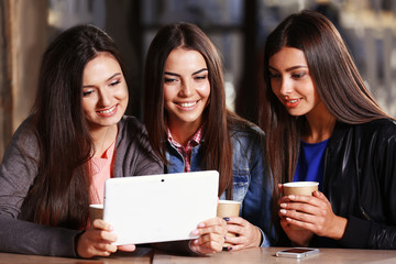 Best friends with tablet together sitting at cafes terrace