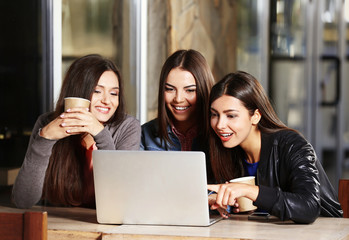 Best friends with laptop together sitting at cafes terrace