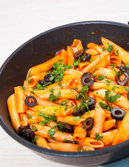 Penne pasta with tomato sauce in a frying pan