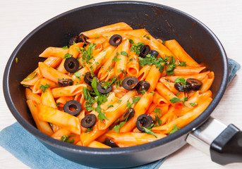 Penne pasta with tomato sauce in a frying pan