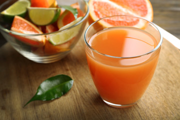 Citrus juice with ice and fresh fruits on cutting board