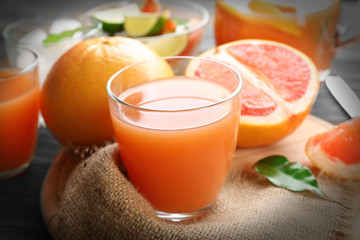 Citrus juice with ice and fresh fruits on cutting board