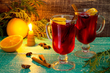Mulled wine with a candle and a decorated Christmas tree in a ru