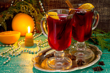 Mulled wine with a candle and a decorated Christmas tree in a ru