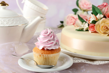 Tasty cupcake on saucer, on light background