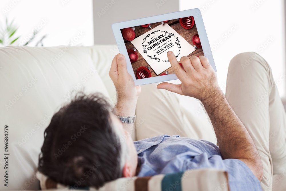 Poster composite image of man laying on sofa using a tablet pc