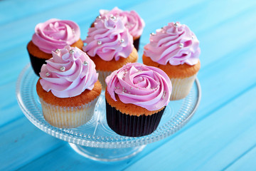 Tasty cupcakes on color wooden background