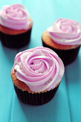 Tasty cupcakes on color wooden background