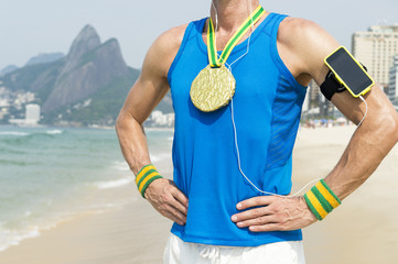 Gold medal athlete wearing mobile phone technology armband stands listening to motivational music...
