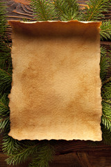 Christmas background - blank paper sheet on branch of spruce tre