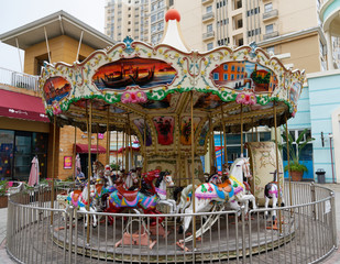 Colourful carousel with horses on a street