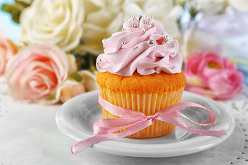 Tasty cupcake on plate, on light background