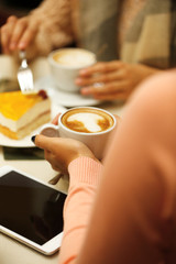 Woman with a tablet and coffee in cafe