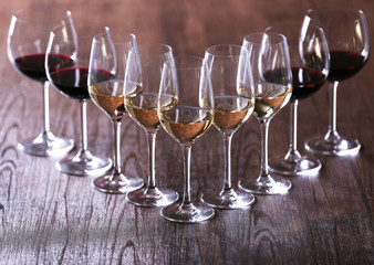 Wineglasses with white, red and pink wine on wooden table close-up