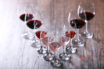 Wineglasses with white, red and pink wine on wooden table close-up
