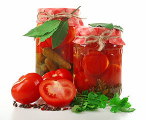 Jars of canned tomatoes and cucumbers isolated on white