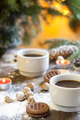 Coffee, tangerines, cookies and nuts in Christmas decor with Christmas tree, nuts and apples on colorful background bokeh