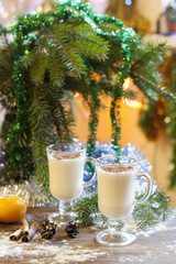 Vanilla panna cotta with chocolate,  tangerines, cones, cinnamon and nuts in Christmas decor with Christmas tree on colorful background bokeh