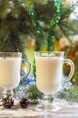 Vanilla panna cotta with chocolate,  tangerines, cones, cinnamon and nuts in Christmas decor with Christmas tree on colorful background bokeh