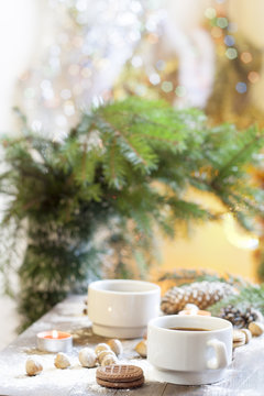 Coffee, tangerines, cookies and nuts in Christmas decor with Christmas tree, nuts and apples on colorful background bokeh