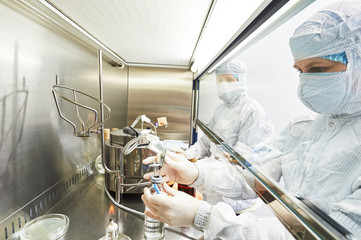 workers in protective uniform at laboratory