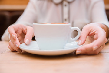 Female hands holding coffee