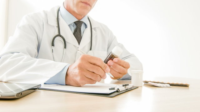 Doctor writing down medical prescriptions.