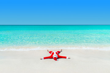 Fototapeta na wymiar Christmas Santa Claus take pleasure sunbathing at tropical ocean