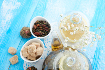Obraz na płótnie Canvas Ripe lemon, cinnamon and fruit drink in glass teapot on wooden background