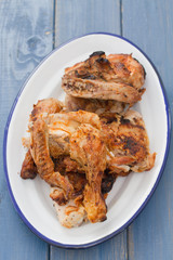 grilled chicken on white dish on blue wooden background