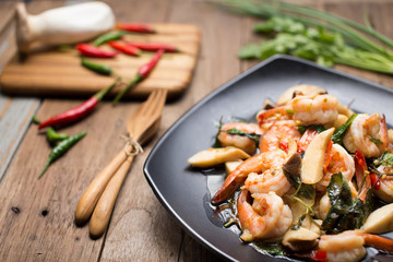 Stir Fried shrimp with Holy Basil with raw material on the wooden background