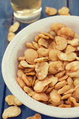 fried beans in white bowl with glass on blue wooden background