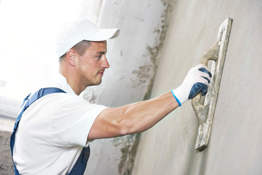 Plasterer at indoor wall renovation