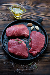 Frying pan with raw marbled meat steaks, selective focus