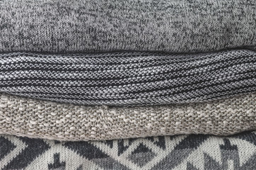 Stack of cozy knitted sweaters; Grey and Black tone.
