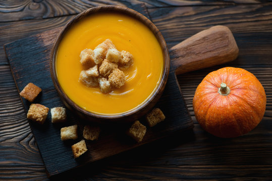 Pumpkin cream-soup served with croutons, high angle view