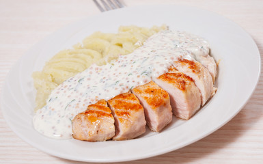 Sliced fried chicken fillet in a creamy and mustard sauce with mashed potatoes