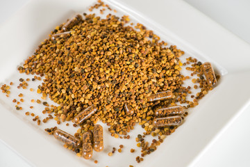 Close-up of Some homeopathic pills with bee pollen in scattered