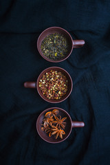 Three cups of spices on the black background