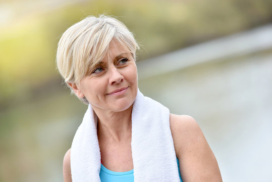 Portrait of athletic senior woman with towel around neck